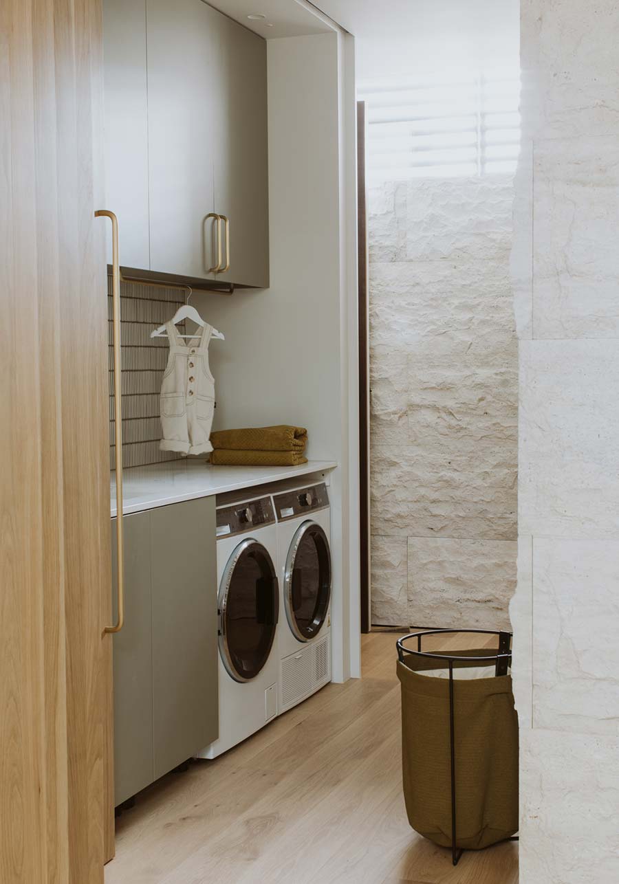 Sage green and wood tone laundry cabinets